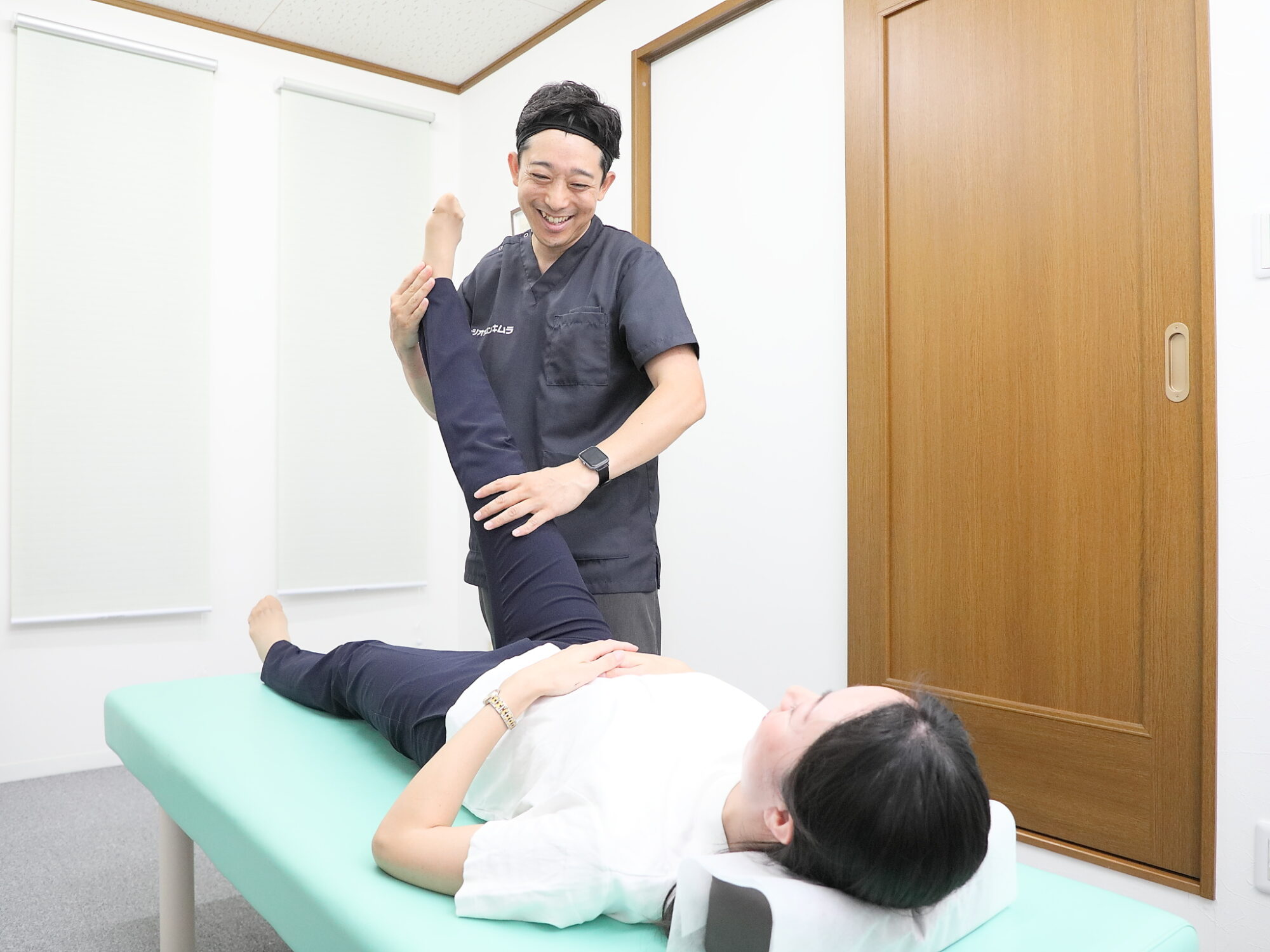 笑顔で施術を行う院長