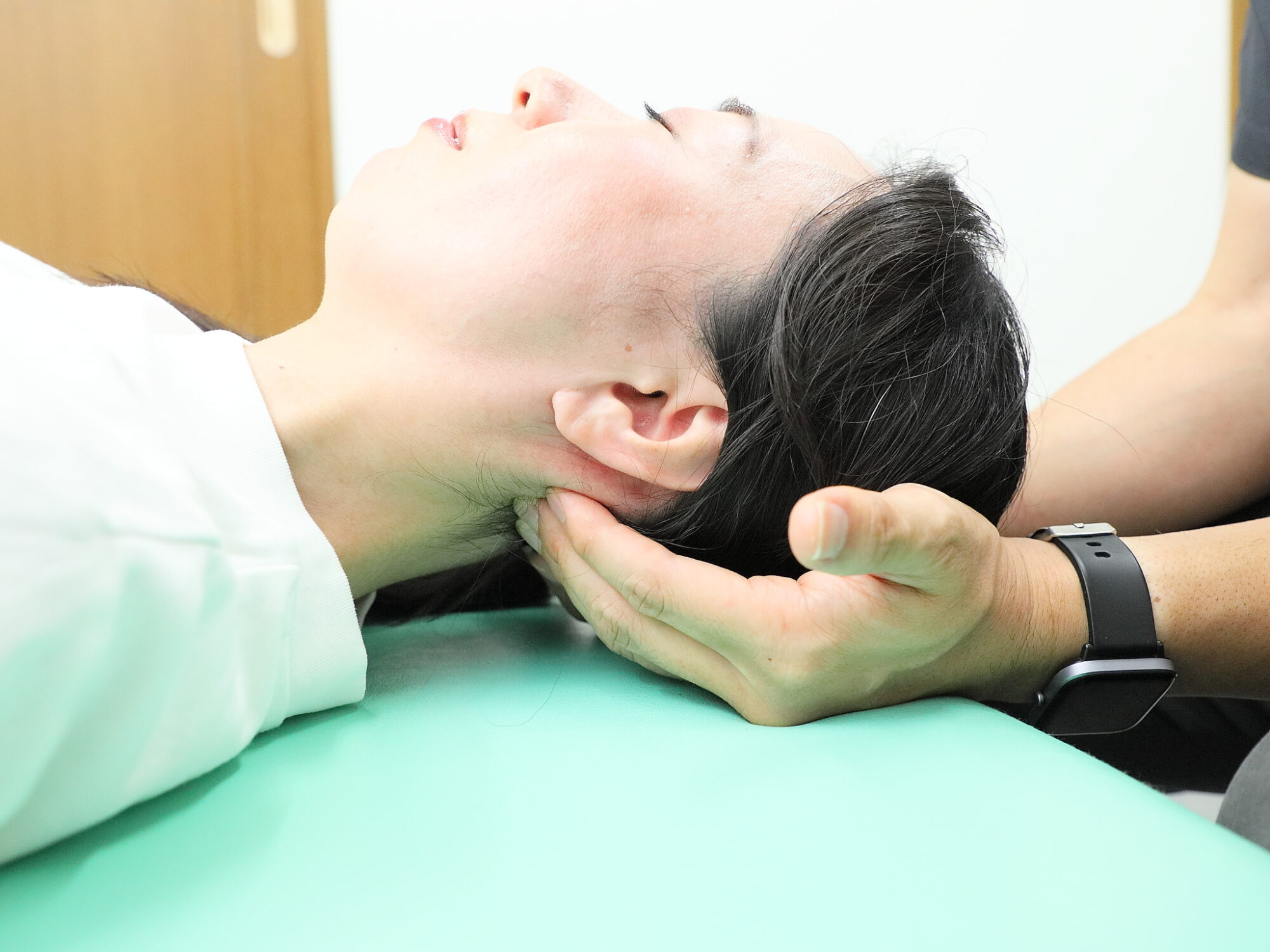 笑顔で施術を行う院長